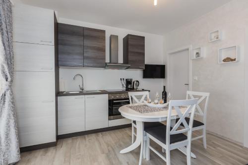 eine Küche mit einem Tisch und Stühlen im Zimmer in der Unterkunft Apartmani Nikola in Plano