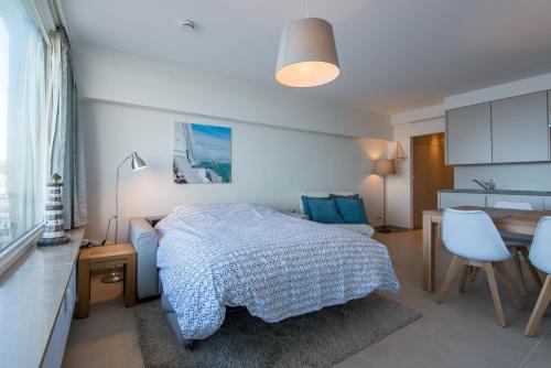 a bedroom with a bed and a table and chairs at Cosy Studio with Sea View in Ostend in Ostend