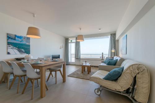 a living room with a table and a couch at Cosy Studio with Sea View in Ostend in Ostend