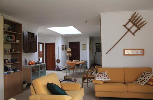 a living room with two couches and a table at Vila Da Praia in Campo de Baixo
