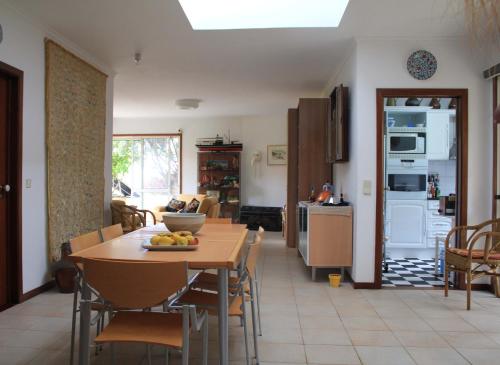 a kitchen and dining room with a table and chairs at Vila Da Praia in Campo de Baixo