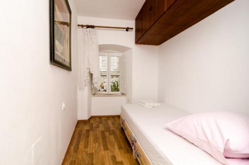 1 dormitorio con cama y ventana en Apartment La Marina, en Dubrovnik