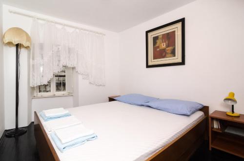 杜布羅夫尼克的住宿－碼頭公寓，白色卧室配有蓝色枕头的床