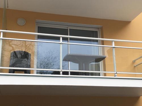 einen Balkon mit weißem Geländer und einem Fenster in der Unterkunft Charmant appartement - Centre d'Arcachon in Arcachon