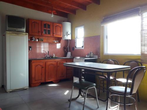 una cocina con armarios de madera, mesa y sillas en Samana Holiday, en Carpintería
