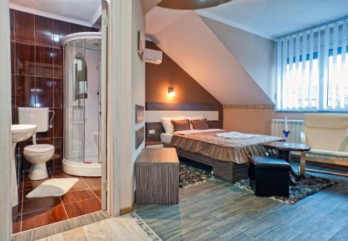 a bedroom with a bed and a bath room at Garni Hotel Lama in Kragujevac