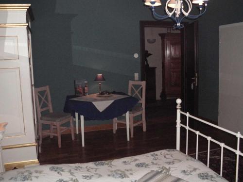 a bedroom with a table and chairs and a bed at Schlosshotel Bredenfelde in Bredenfelde
