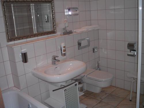 a bathroom with a sink and a toilet at Schlosshotel Bredenfelde in Bredenfelde