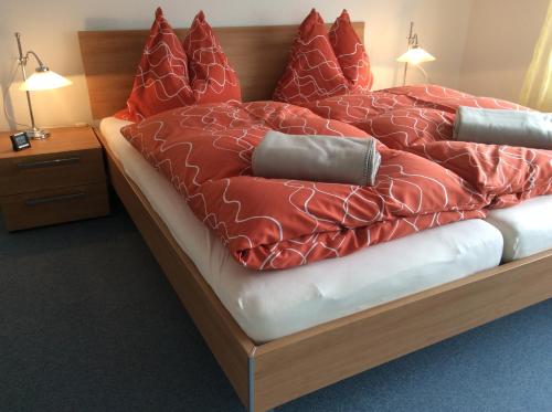 uma cama com edredão vermelho e almofadas em Heidelberg Appartements Berger em Heidelberg