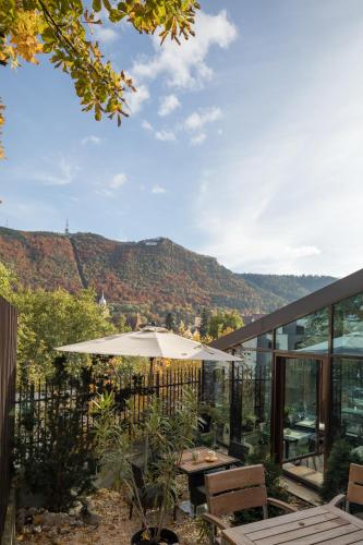 a patio with an umbrella and a view of the mountains at Villa Prato in Braşov