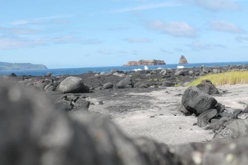 a group of rocks on a beach with the ocean at Vila Barca in Madalena