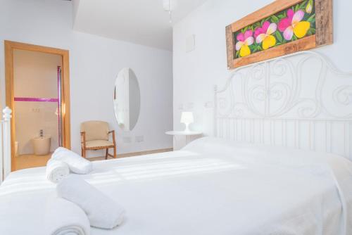 a white bedroom with a white bed with towels on it at Son Pujol in Montuiri