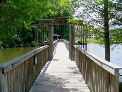 a wooden bridge over a river with a sign on it at Vacation Village at Parkway in Orlando