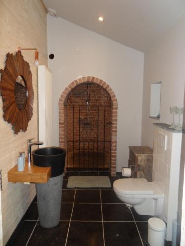 a bathroom with a toilet and a bathroom with a gate at B&B 'Het Logiement in Sint-Maria-Lierde