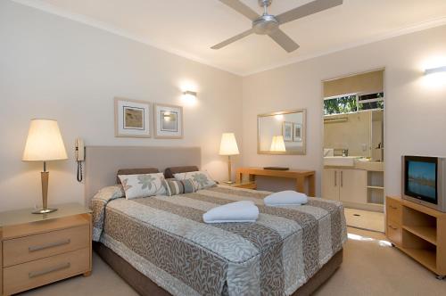 a bedroom with a large bed and a television at Bali Hai Apartments Noosa in Noosa Heads