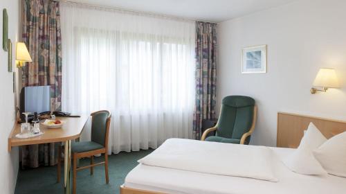 a hotel room with a bed and a table and chairs at Hotel Lamm in Ostfildern