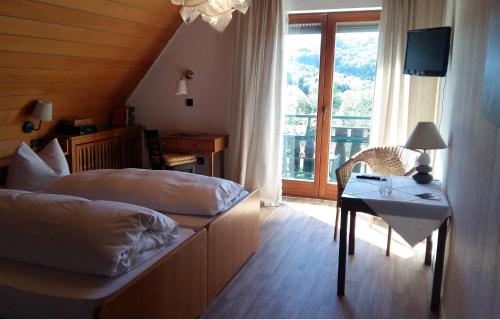 a bedroom with two beds and a table and a window at Landgasthof Grüner Baum in Badenweiler