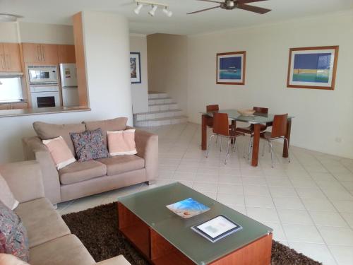 a living room with a couch and a table at Bali Hai Apartments Noosa in Noosa Heads