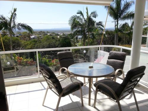 a patio with a table and chairs on a balcony at Bali Hai Apartments Noosa in Noosa Heads