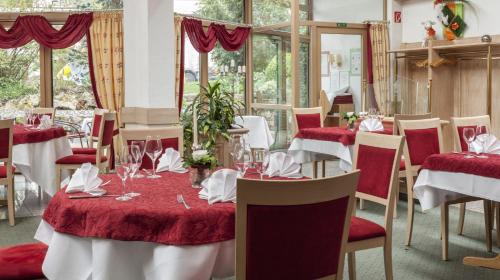 a dining room with red and white tables and chairs at Hotel Lamm in Ostfildern
