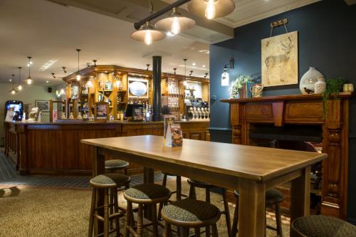 a bar with a wooden table and chairs at Toby Carvery Doncaster by Innkeeper's Collection in Doncaster