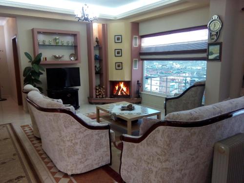 a living room with a fireplace and a table and chairs at Eagle house in Përmet