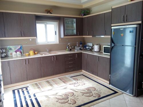 a kitchen with wooden cabinets and a black refrigerator at Eagle house in Përmet
