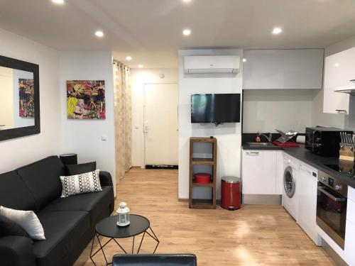 un salon avec un canapé et une cuisine dans l'établissement Studio Mandelieu, à Mandelieu-la-Napoule