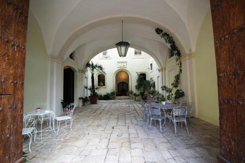 un pasillo con mesas y sillas en un edificio en Palazzo De Castro, en Squinzano