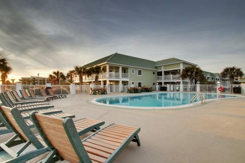a swimming pool with lounge chairs and a resort at Islander Hotel & Resort in Emerald Isle