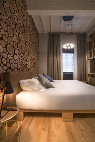 a bedroom with a large white bed with wooden floors at Benci House in Florence