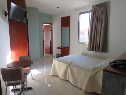 a bedroom with a bed and a table and a television at Hotel San Juan Periferico in Villahermosa
