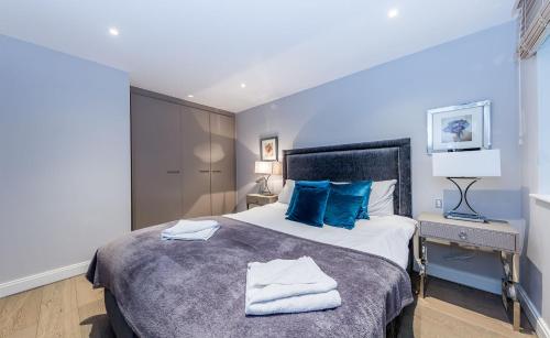 a bedroom with a large bed with blue pillows at Lux St James Park Apartment Central London FREE WIFI by City Stay Aparts London in London