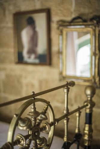 a gold railing with a mirror and a picture at The Burrow Guest House in Tarxien
