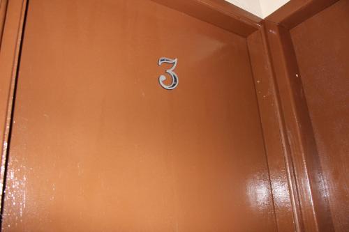 a wooden door with the number three on it at Edicula Fundos in Jordãozinho