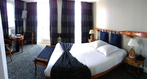 a hotel room with a large bed and a large window at Le Querrien in Cancale