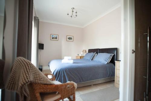 a bed sitting in a bedroom next to a window at Ballas Farm Country Guest House in Bridgend