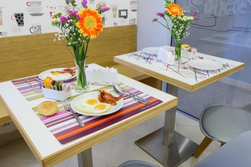 two tables with breakfast foods and flowers on them at Un B&B al Belvedere in Enna