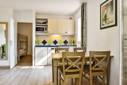 eine Küche und ein Esszimmer mit einem Tisch und Stühlen in der Unterkunft Résidences du golf in Saint-Raphaël