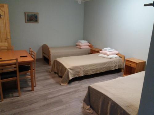 een kamer met 2 bedden, een tafel en een bureau bij Westwind puhkemaja in Kunda