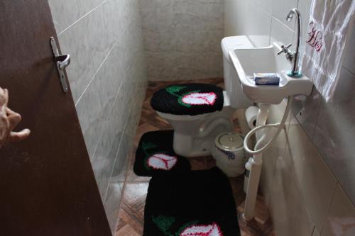 a bathroom with a toilet and a sink at Edicula Fundos in Jordãozinho
