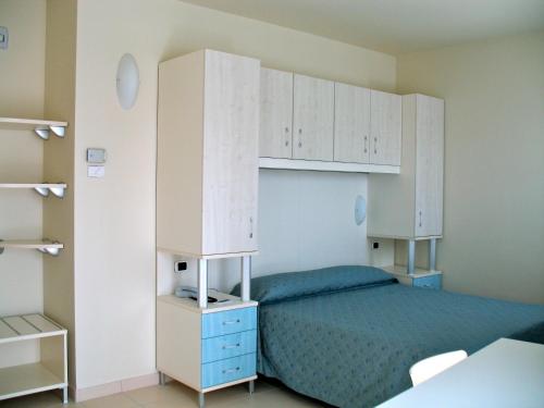 a bedroom with a bed and white cabinets at Hotel Residence HR CIVI in Tortoreto Lido