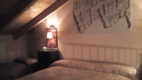 a bedroom with a bed and a lamp on a wall at Valli Unite in Costa Vescovato