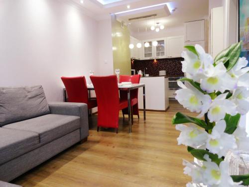 ein Wohnzimmer mit einem Sofa und einem Tisch mit roten Stühlen in der Unterkunft Na Grobli 014 in Breslau