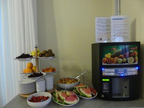 un bancone con ciotole di frutta e un microonde di Hotel Madison a Lido di Jesolo
