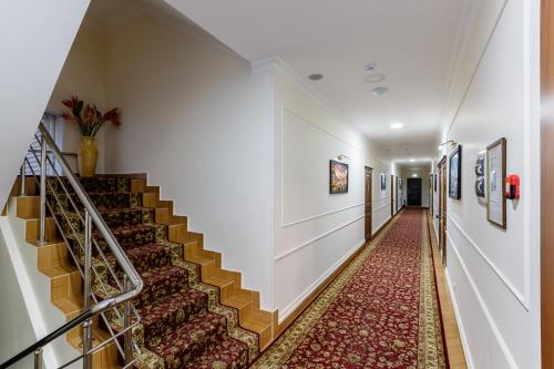 a long hallway with stairs and a rug at Brown Hotel in Astana
