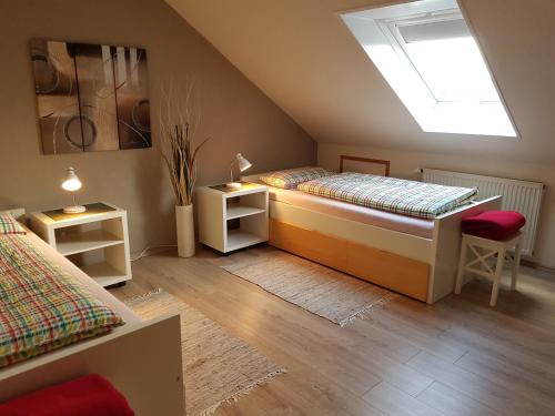 a attic bedroom with two beds and a skylight at Haus Homann-Schneider, Apartment Stefan in Wetter