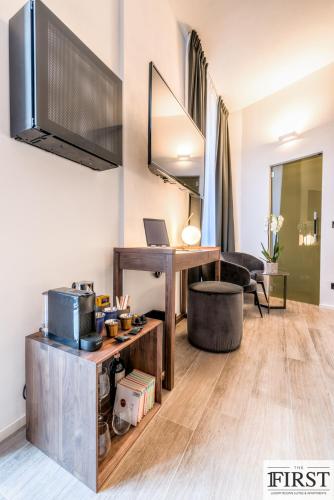 a living room with a desk with a laptop on it at La Spezia by The First - Luxury Rooms & Suites in La Spezia