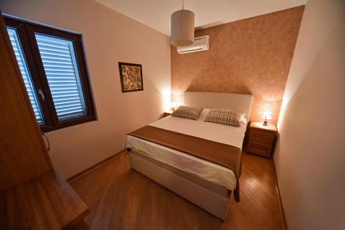 a small bedroom with a bed and a window at Villa Dub in Kotor
