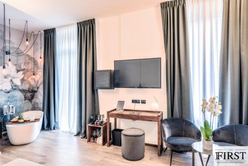 a living room with a desk and a tv at La Spezia by The First - Luxury Rooms & Suites in La Spezia